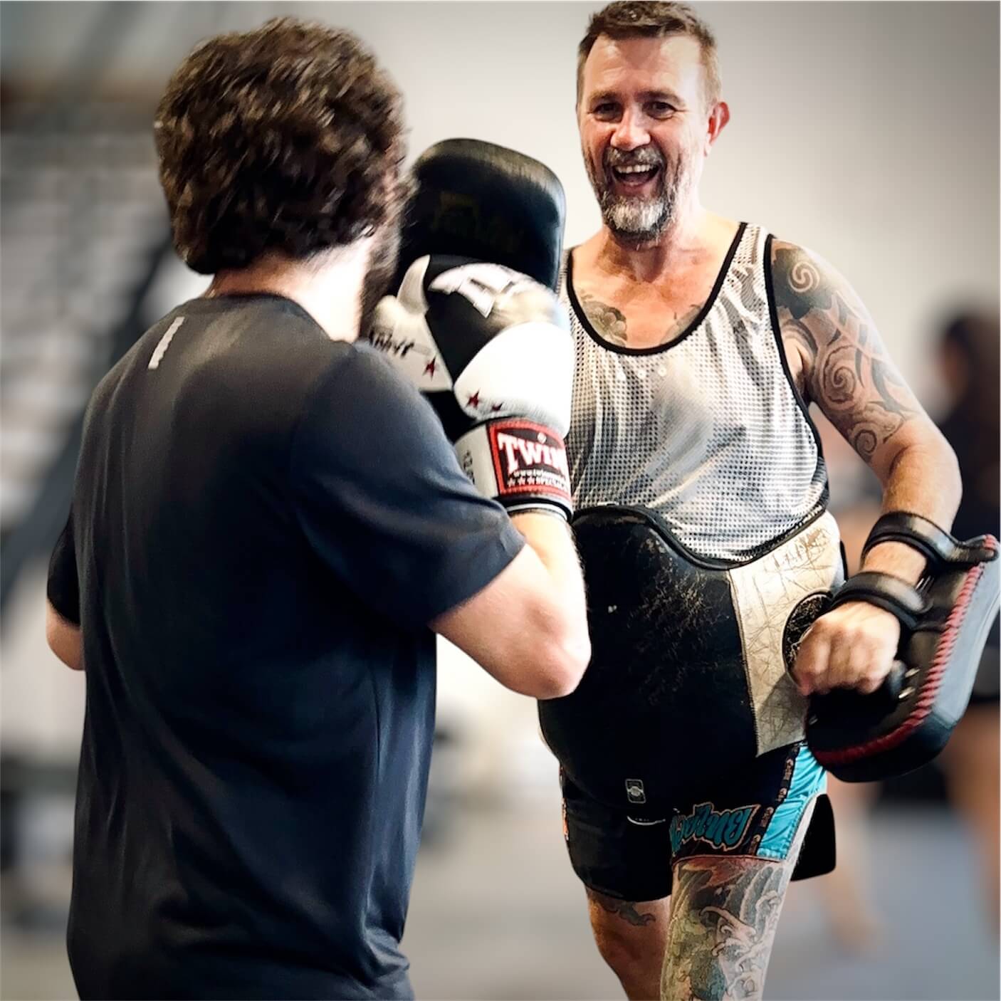 Carl smiling while coaching a student on the pads
