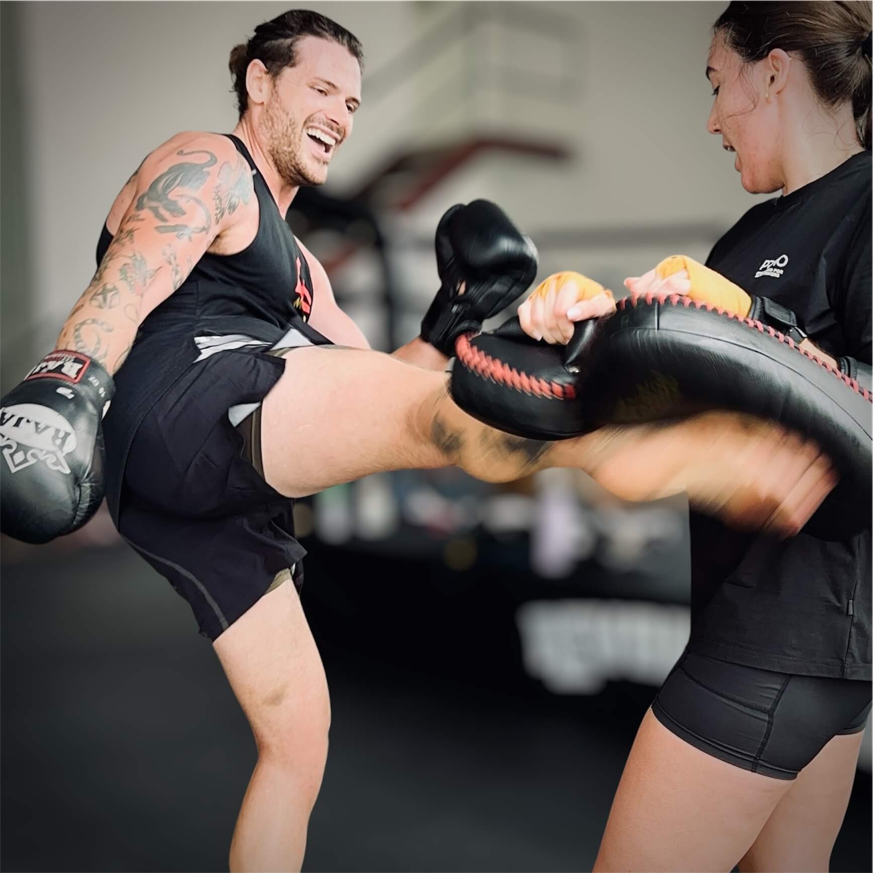 Members smiling during Muay Thai pad training